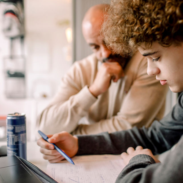 Jongen maakt huiswerk met docent