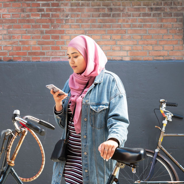 Meisje met telefoon en fiet