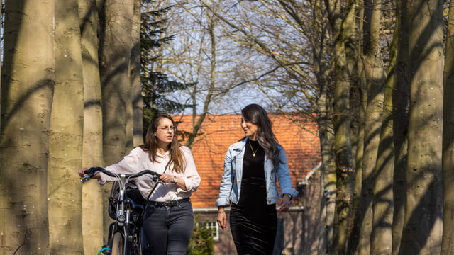 twee vrouwen wandelen met fiets