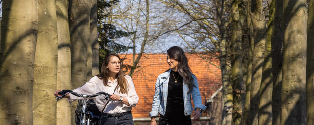 twee vrouwen wandelen met fiets