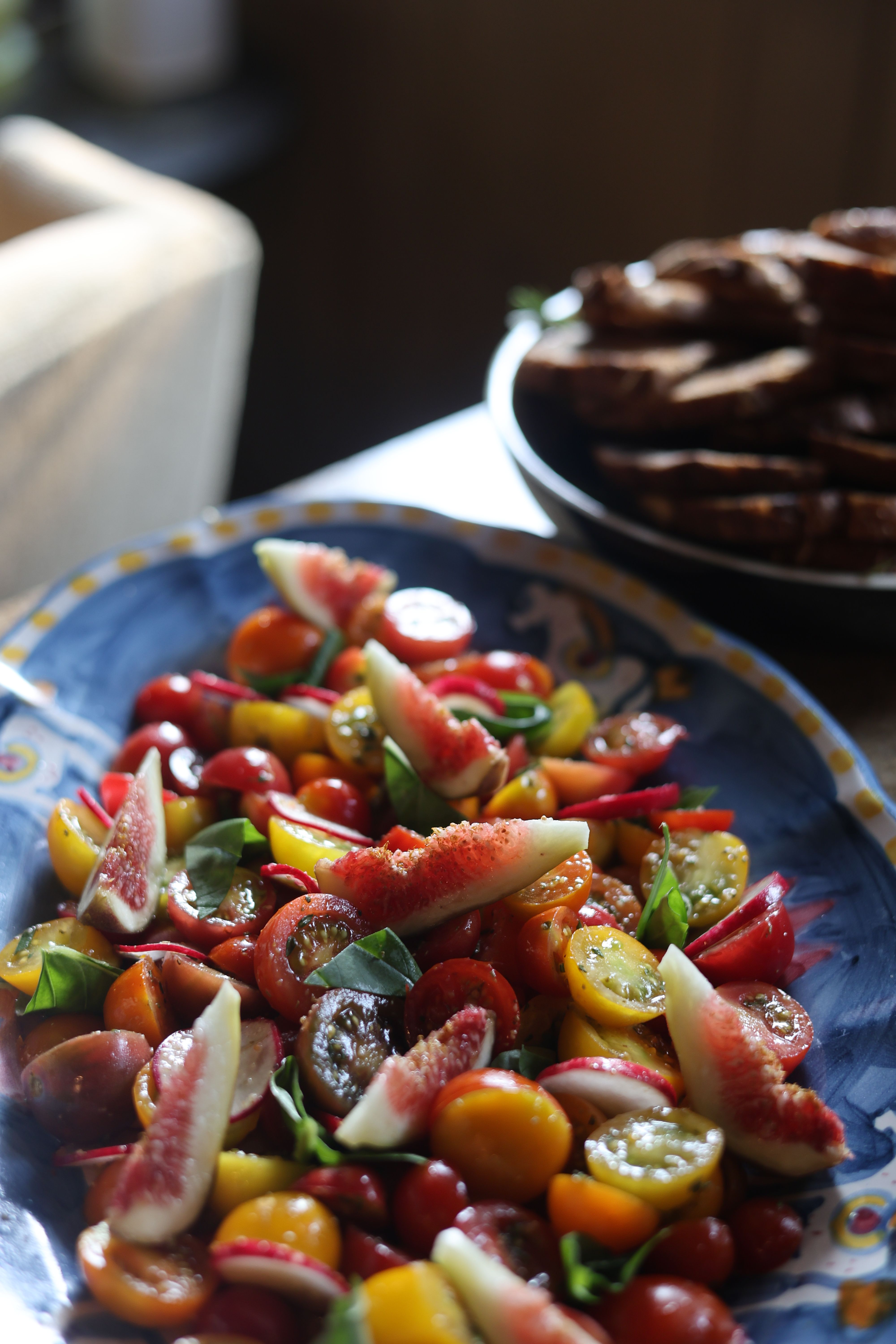 Heirloom tomato salad served family-style with basil oil and sherry vinaigrette