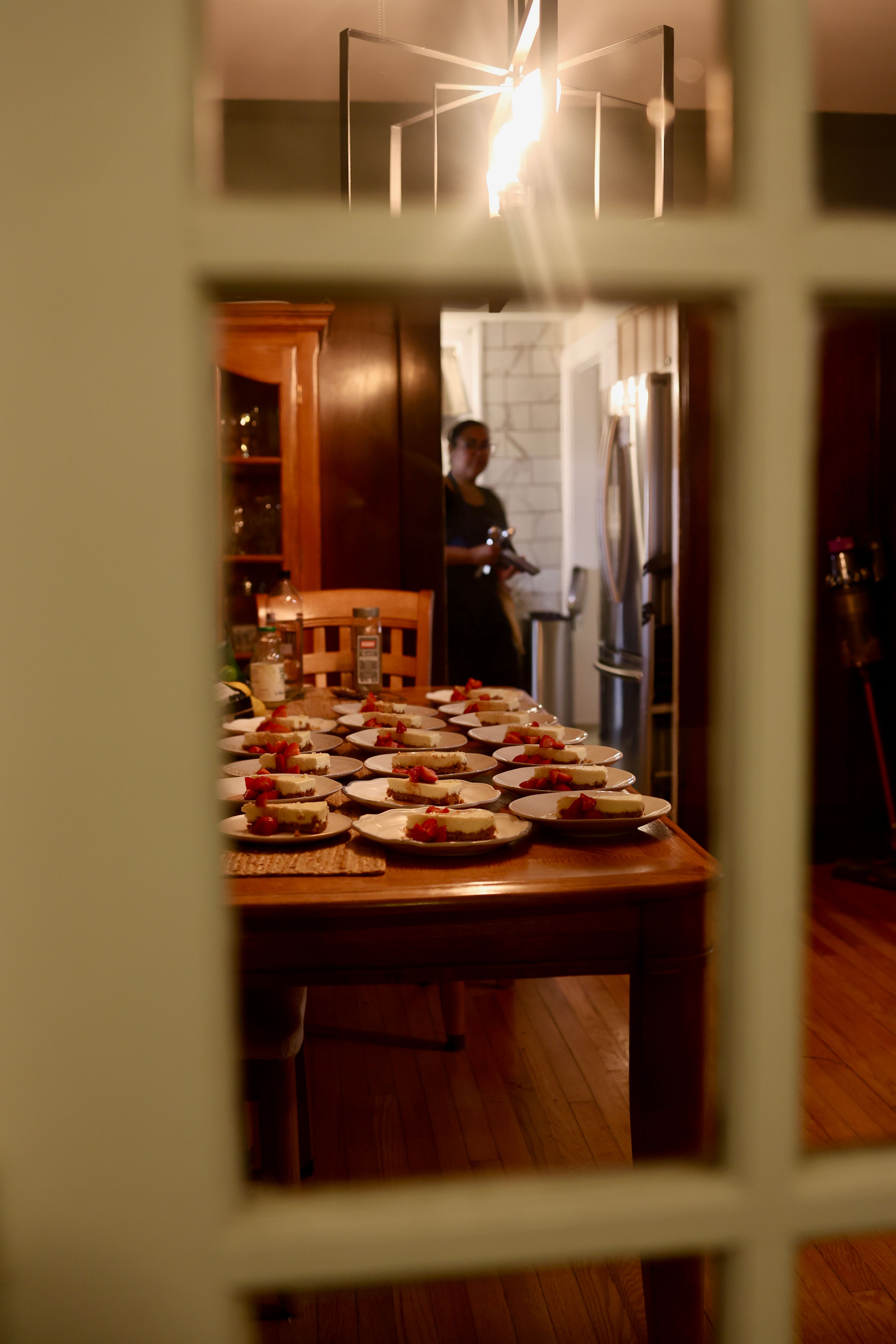 Chef team plating dessert viewed through kitchen window