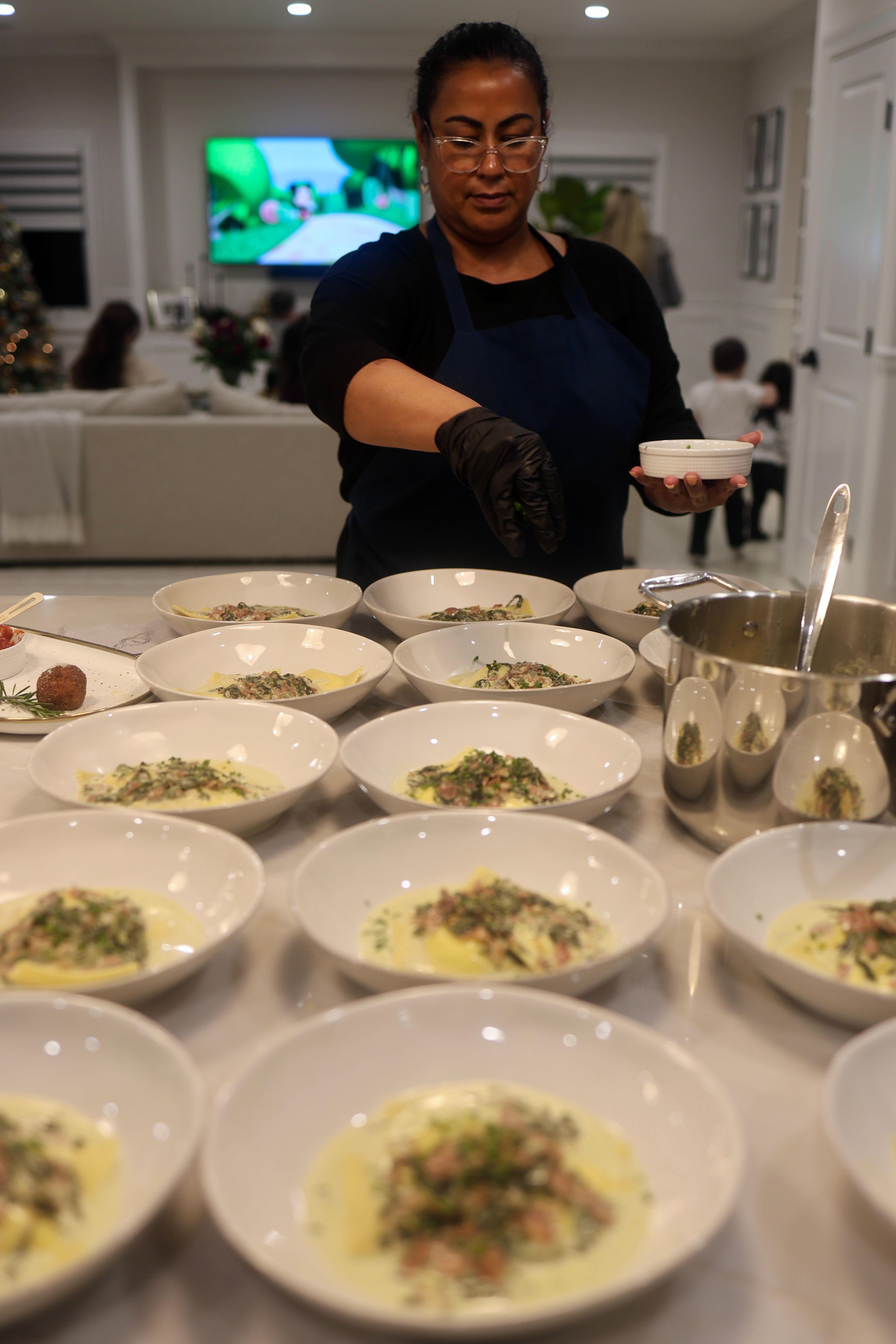 Team plating fresh pasta dishes in a private kitchen