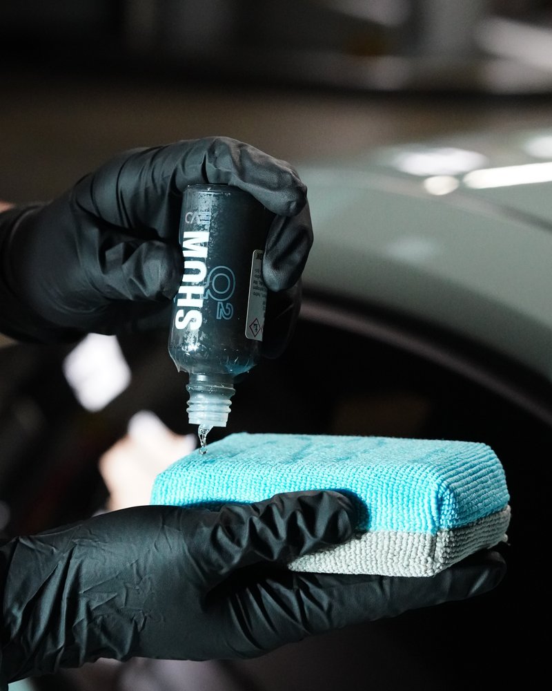 Ceramic coating being dripped onto an applicator pad before installation