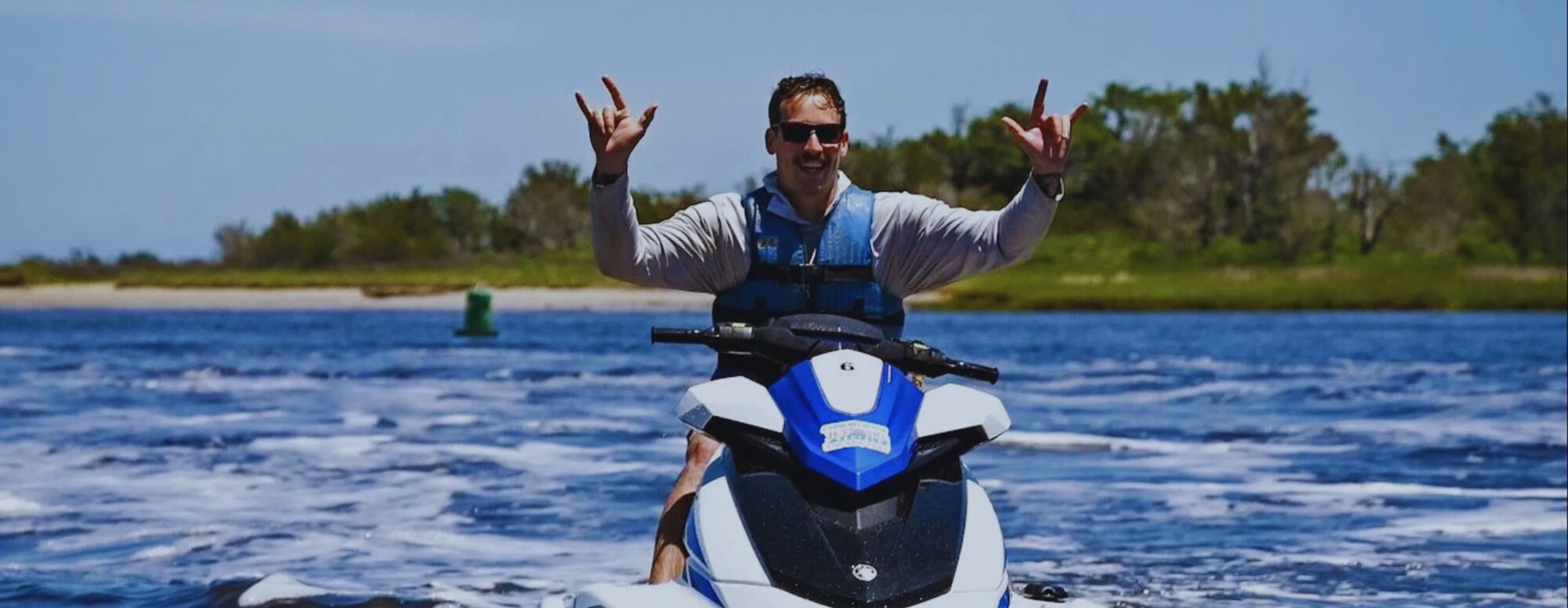Person on a jet ski making a hand gesture on the water