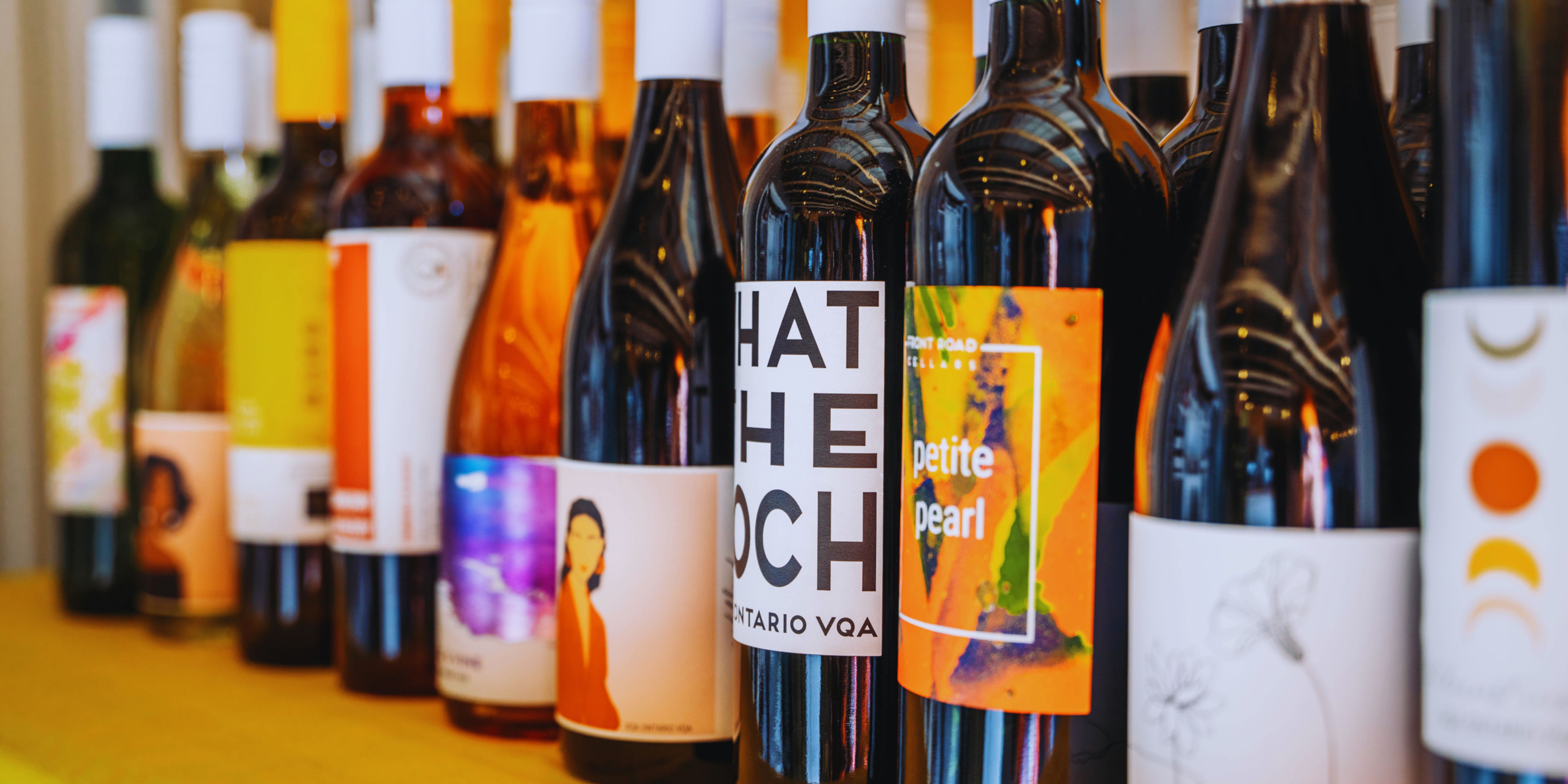 A variety of wine bottles displayed on a shelf with colorful labels.