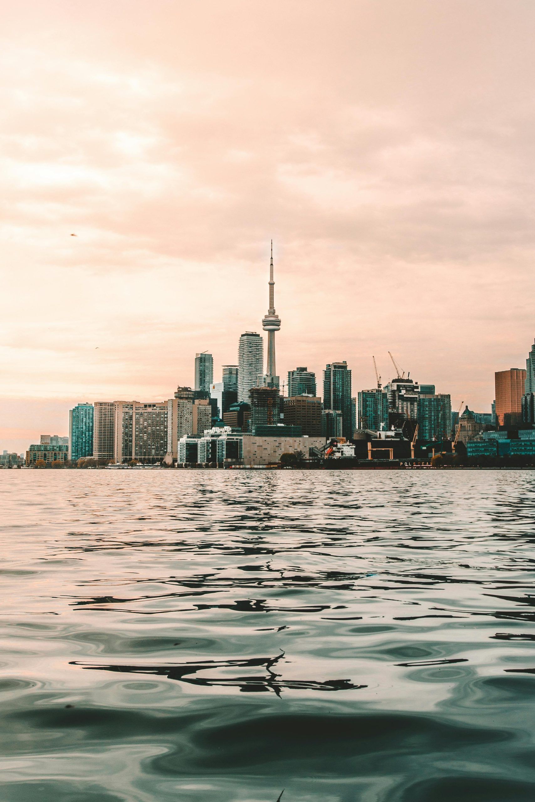 Toronto skyline with CN Tower at sunset over water