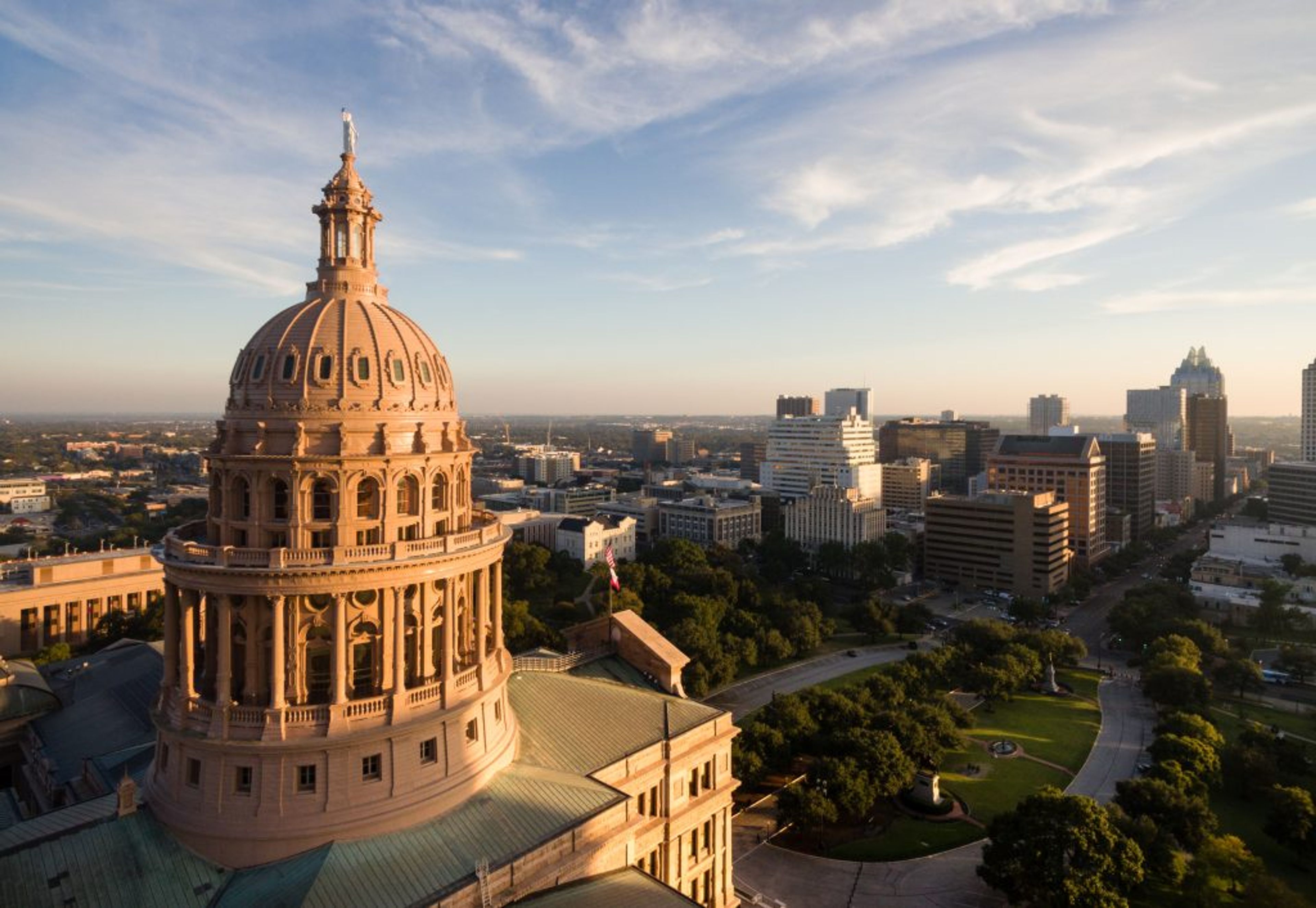 Aerial view of the Texas State Capitol dome with city skyline in the background.