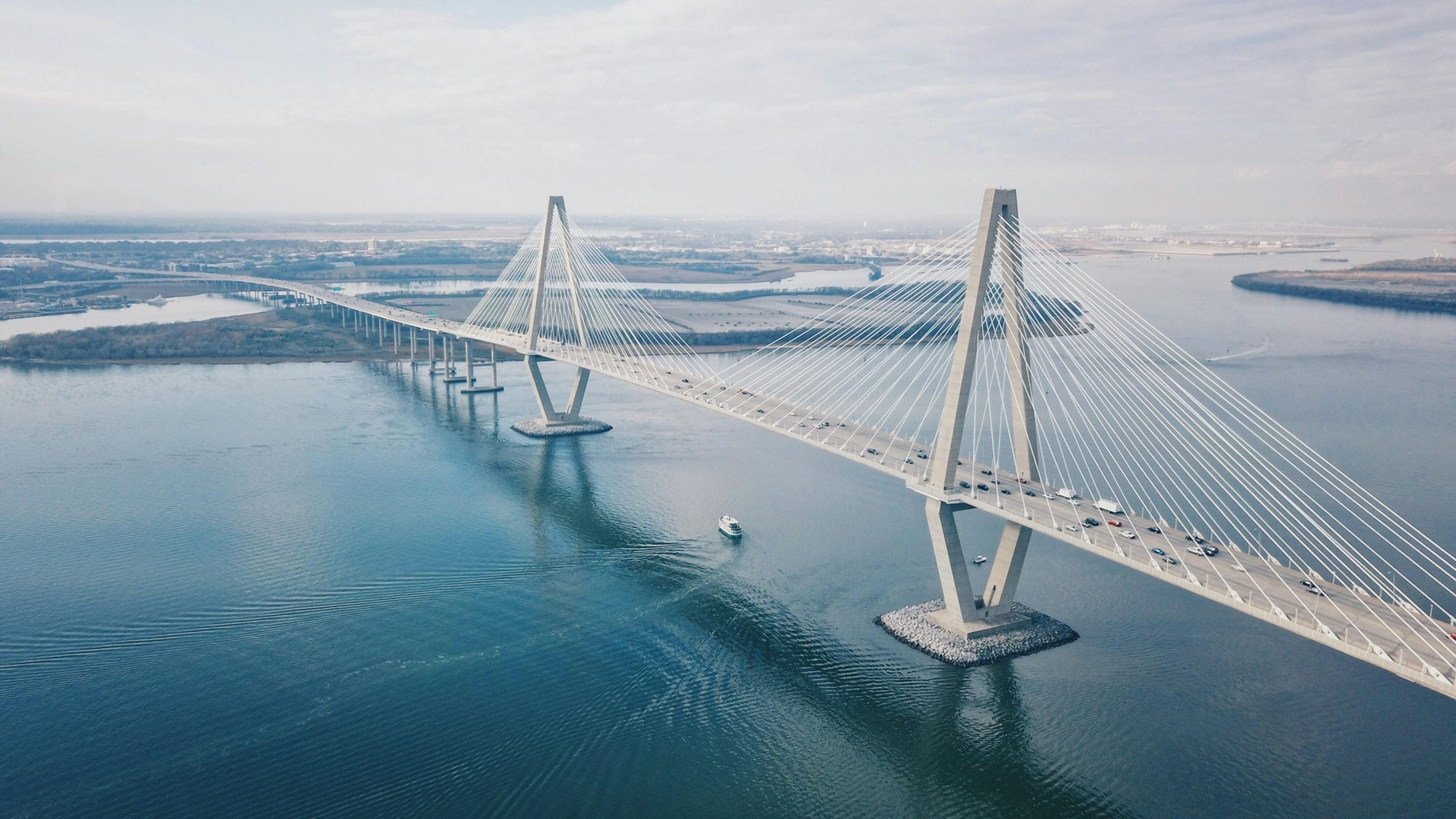 Aerial view of a modern cable-stayed bridge over calm waters.