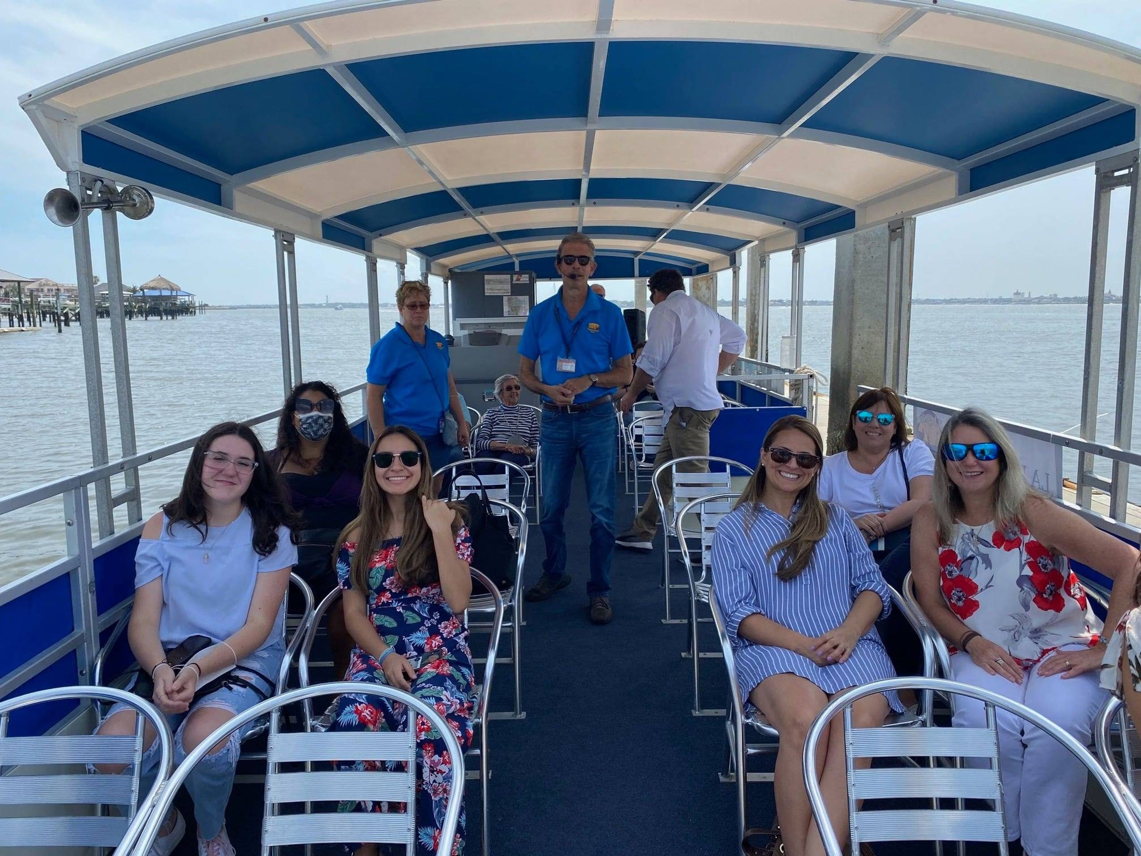 Group of people on a boat tour, enjoying the view on a sunny day.