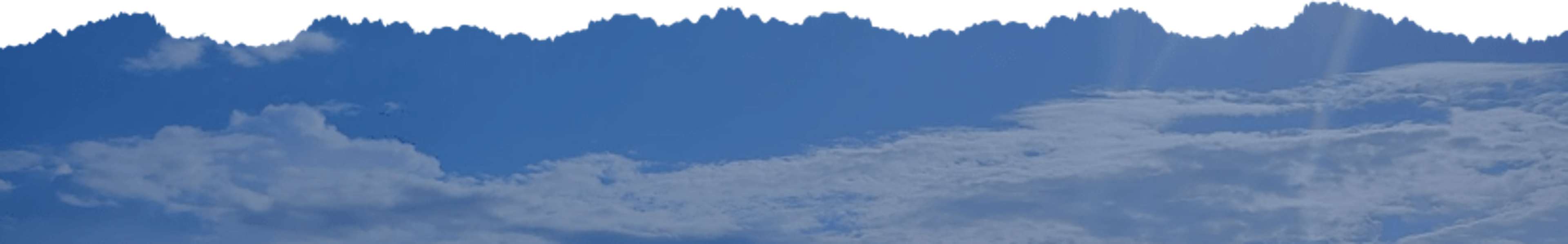Clear blue sky with scattered clouds and sunlight streaming through
