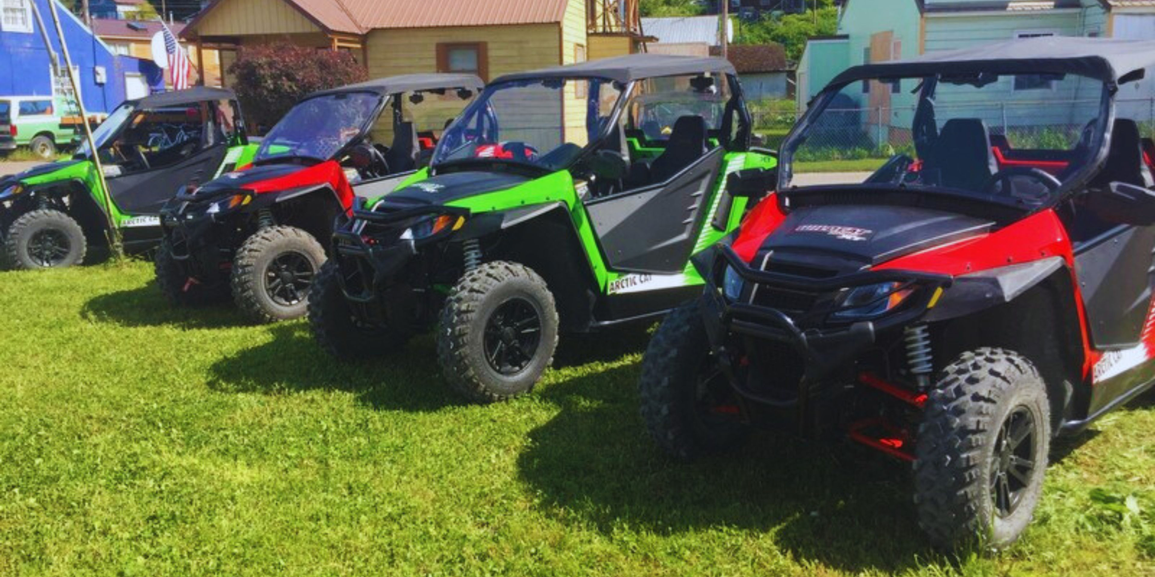 Four colorful off-road vehicles parked on grass
