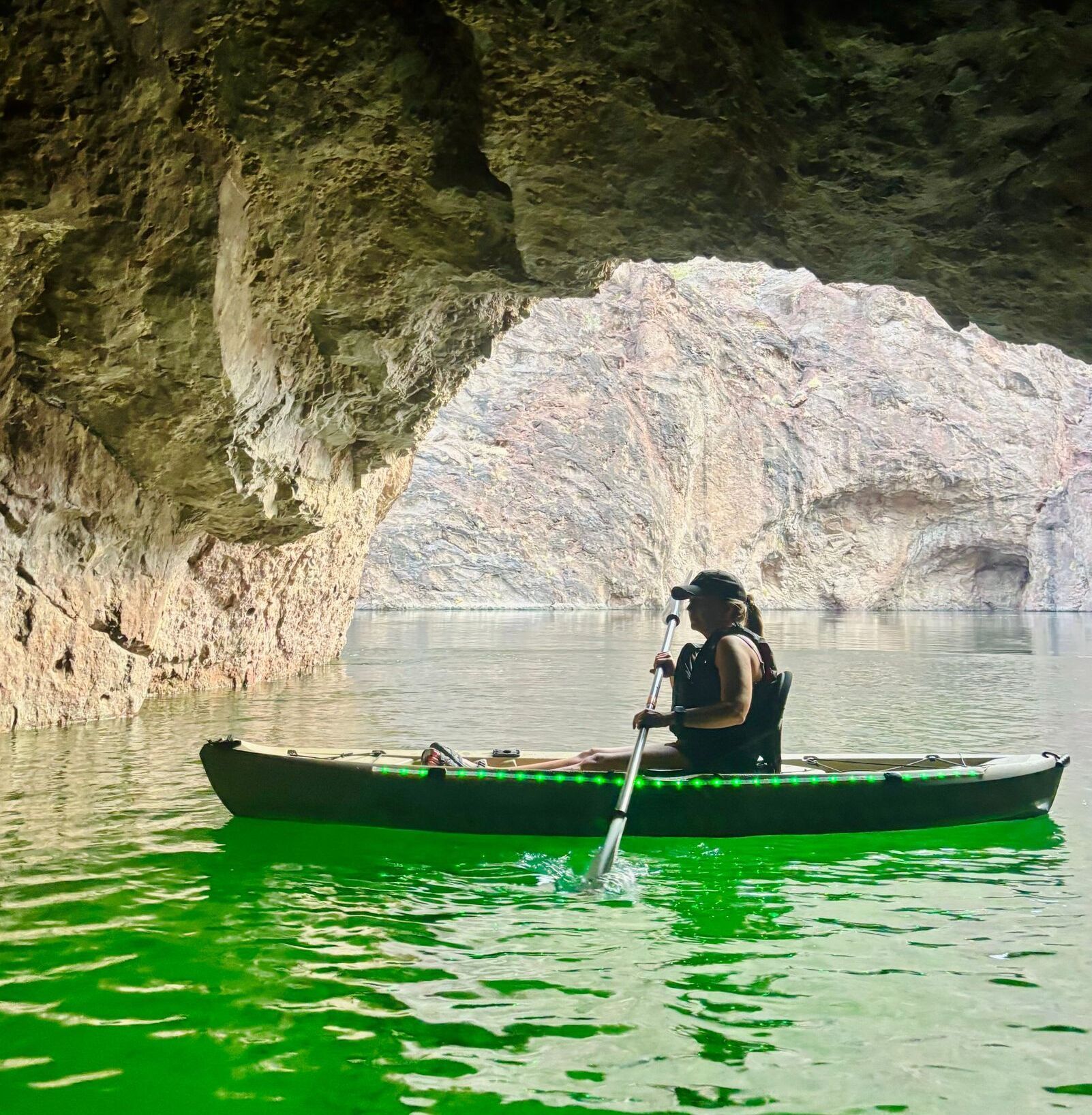 A guest enjoys the emerald cave in a glowing LED kayak on the calm waters of the Colorado River