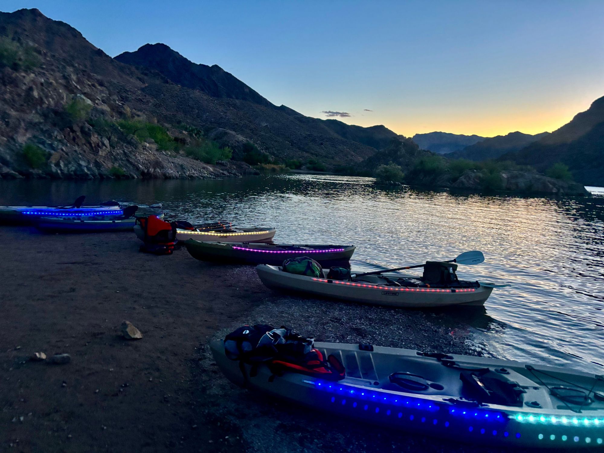 Illuminated kayaks glow on the beach near Lake Mead.