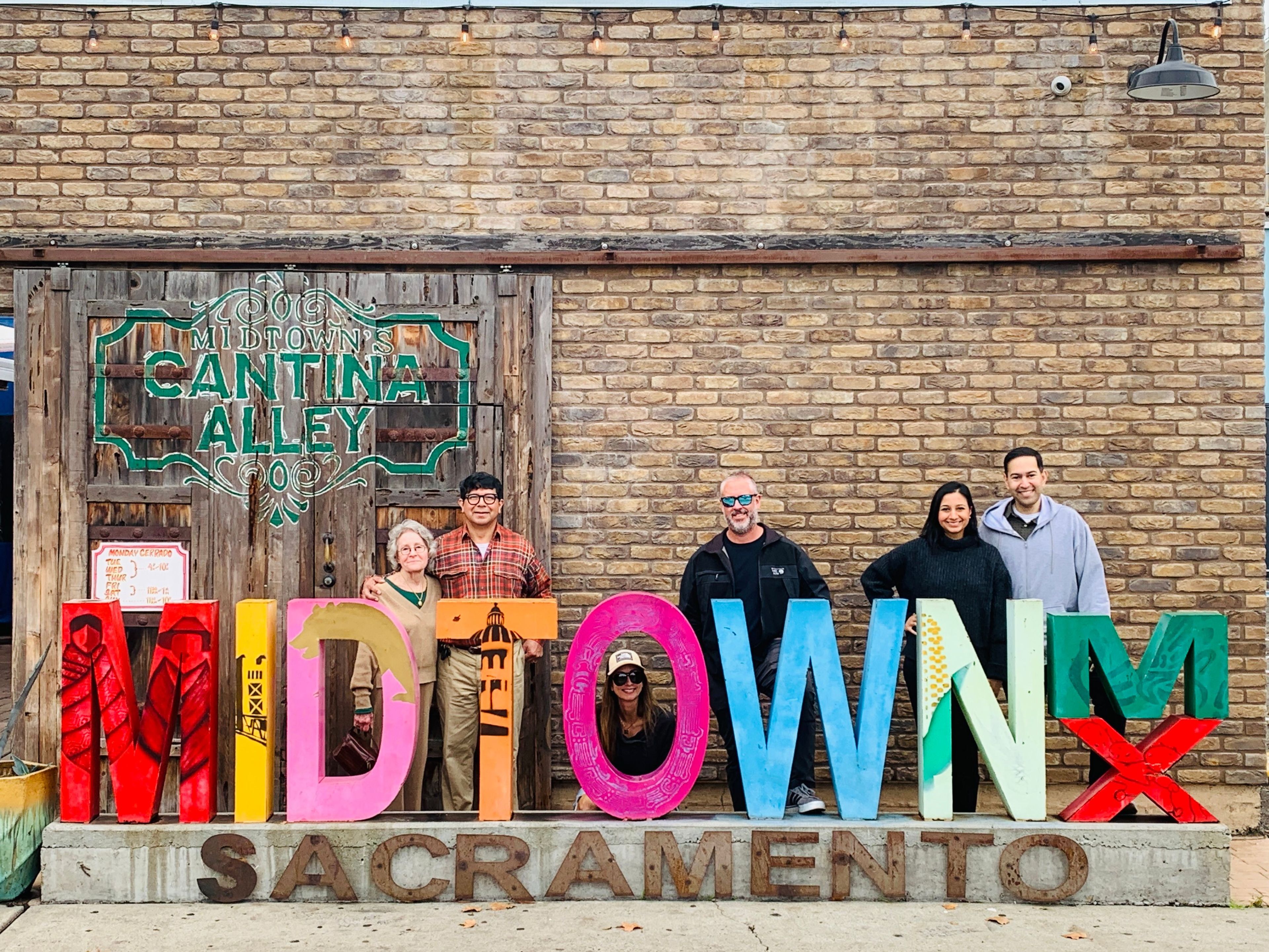 people by a sign that says Midtown