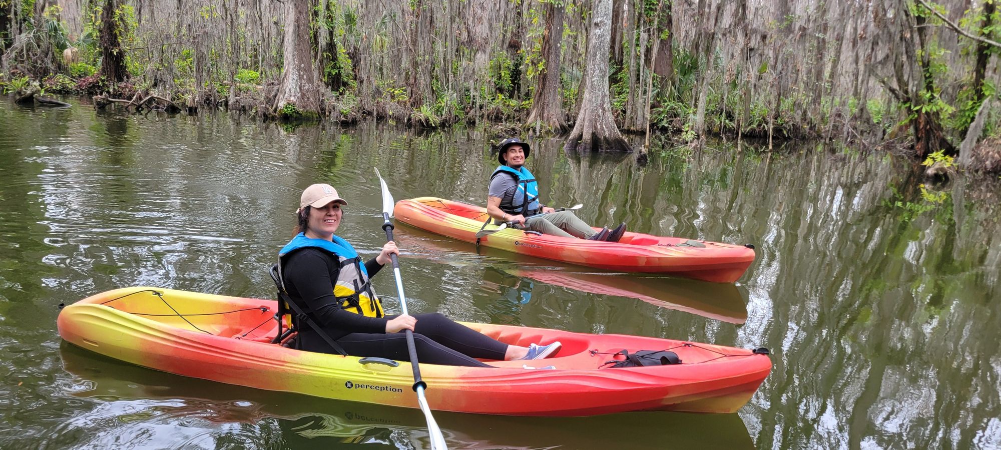 Kayakers paddling through the scenic Dora Canal, surrounded by lush cypress trees and wildlife.