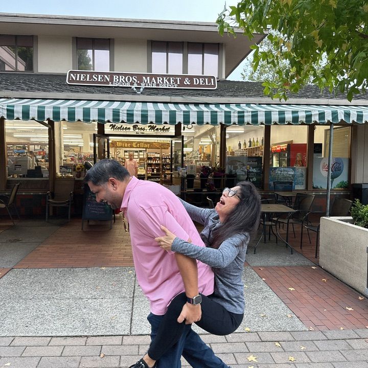 A man gives a precarious piggyback ride to a woman