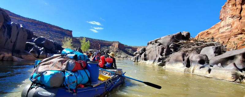 Rafting through black rocks on the Ruby Horsethief section