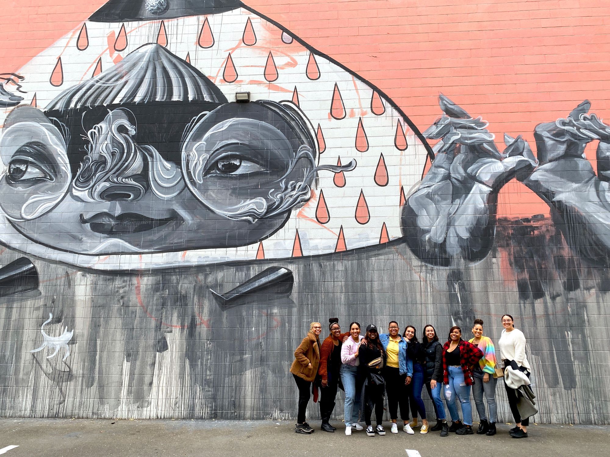 group in front of a mural