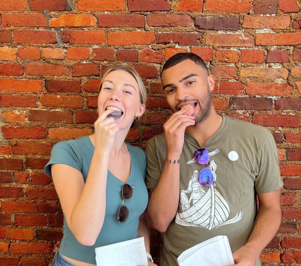 A couple smiling and eating macarons showing why a Riverside Food Tour Gift Certificate or Card is the perfect gift in Cincinnati Ohio