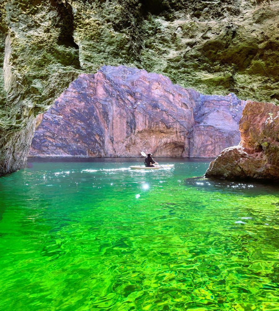 Afternoon kayak tour with bright emerald water glow inside Emerald Cave