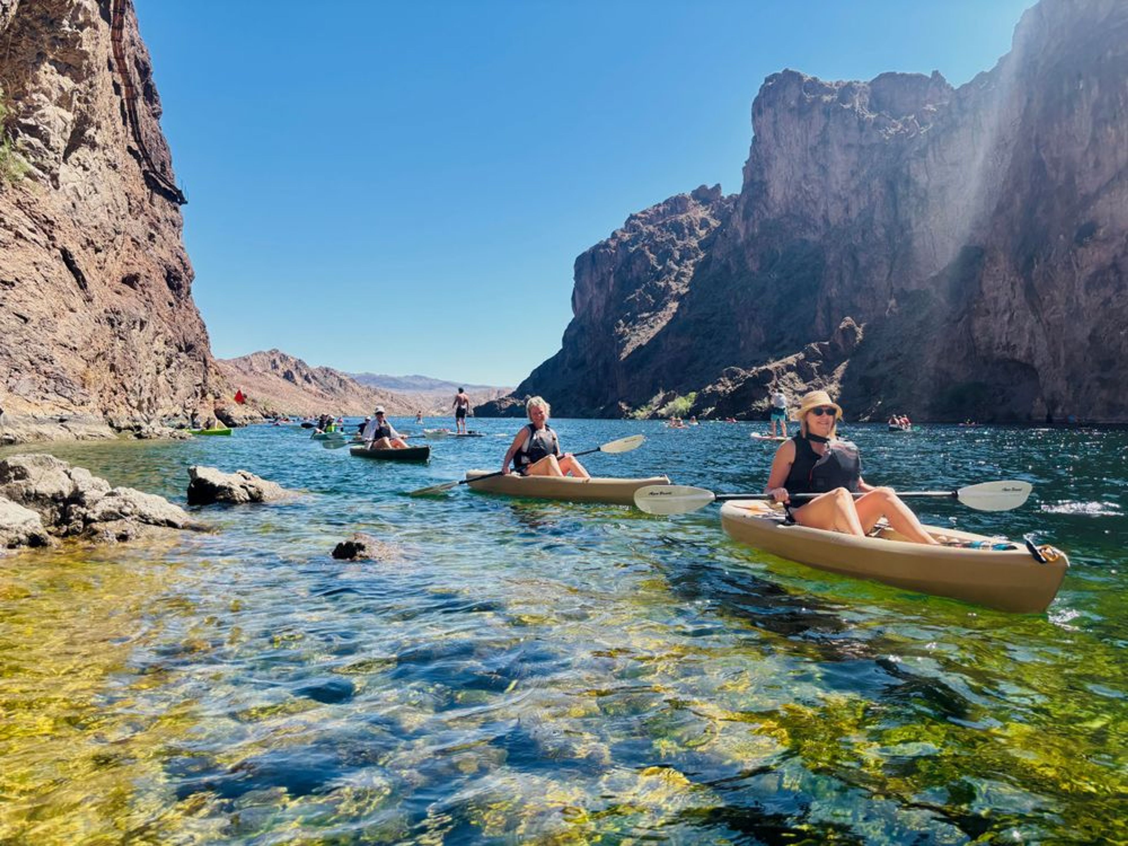 Friends paddling through the Black Canyon Narrows on a private Emerald Cave kayak tour.