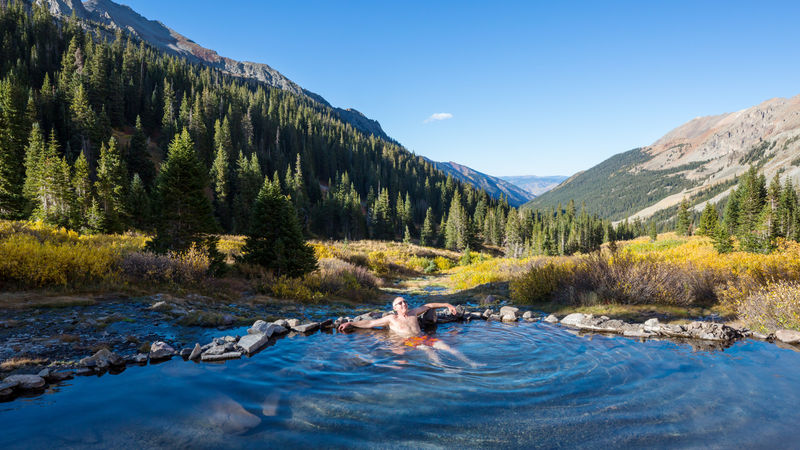 man sitting in hot springs on the Colorado Hot Springs Loop