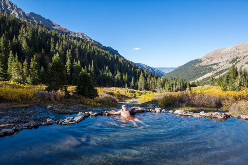 person soaking in hot springs in the mountains near Pagosa Springs