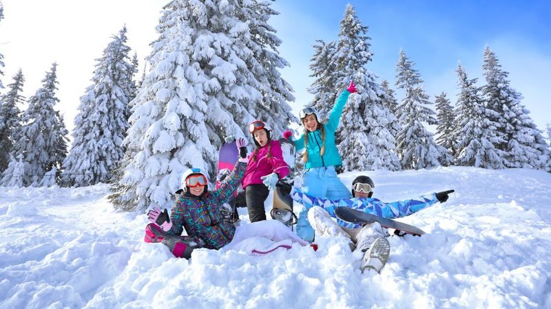 people laying in the snow with their snowboarding and skiing gear on