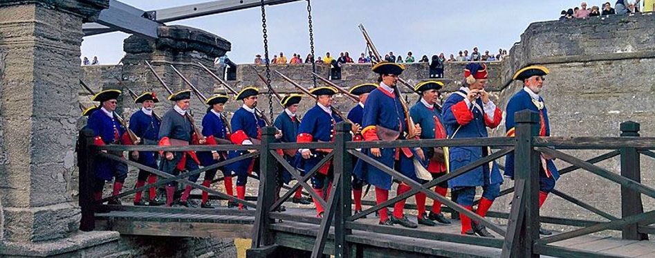 a group of people standing on top of a wooden fence