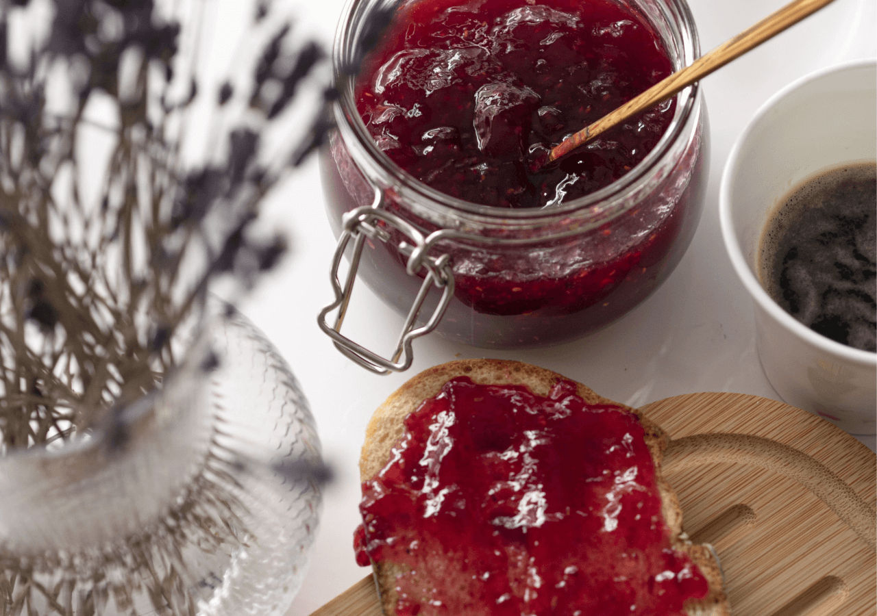 Close up of jam on toast with jar of jam to the side
