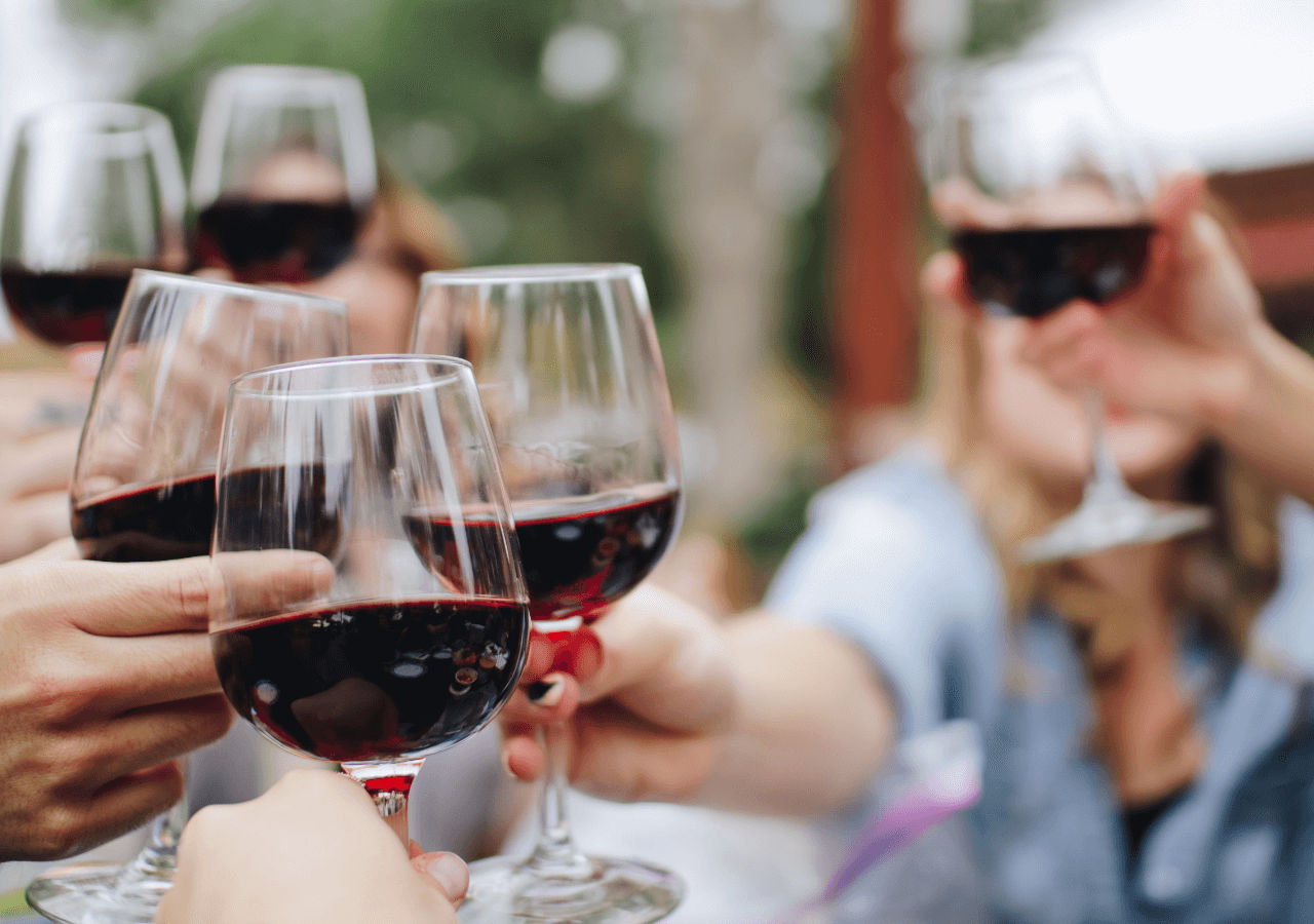 Red wine cheers with hands reaching in