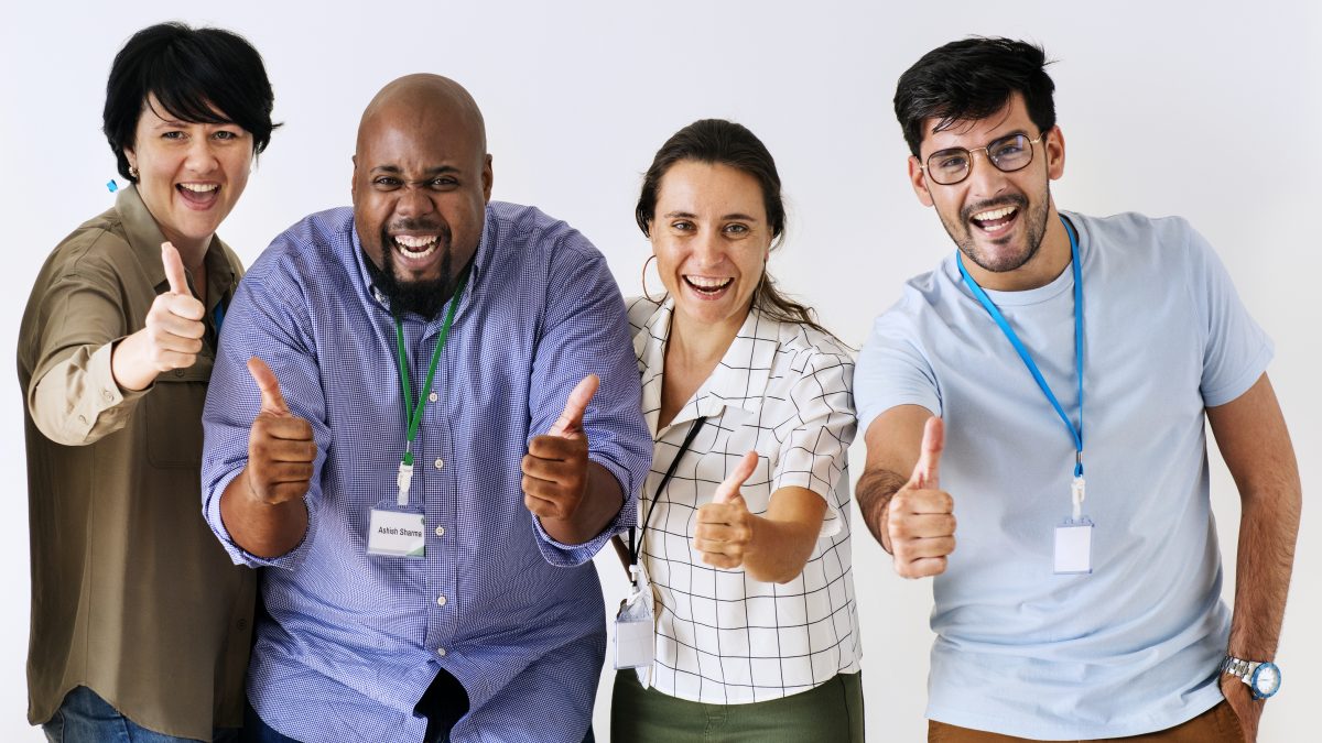 equipe de funcionários multiracial de pé com mãos estiradas para frente com o polegar levantado em sinal positivo