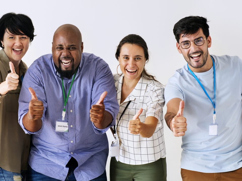 equipe de funcionários multiracial de pé com mãos estiradas para frente com o polegar levantado em sinal positivo