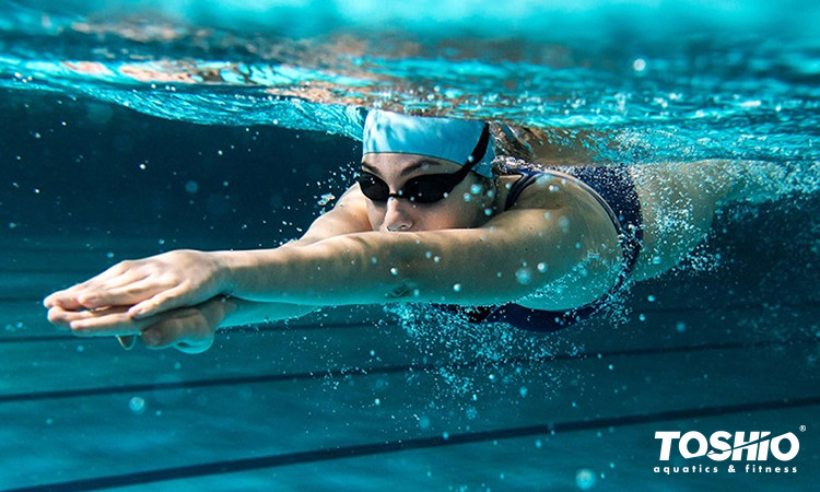 mulher submersa em piscina praticando natação