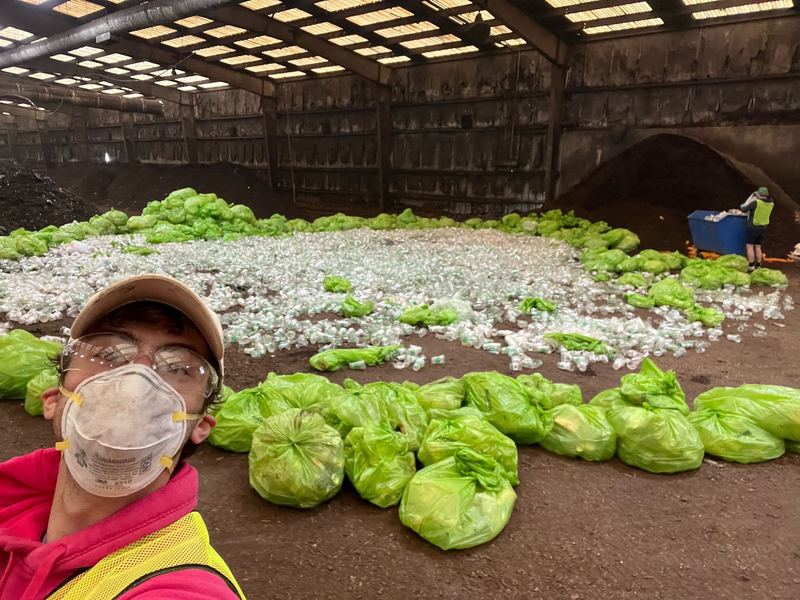 Earth Cups spread across the floor of a commercial composting facility, with bagged collections alongside