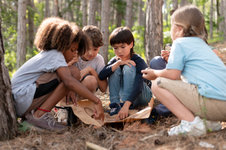 Kinder im Wald, die eine Karte betrachten (Freepik)