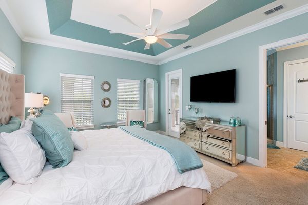 The master bedroom features a King size bed, en-suite bathroom, and private balcony with view to the pool area