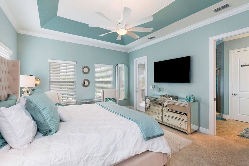 The master bedroom features a King size bed, en-suite bathroom, and private balcony with view to the pool area