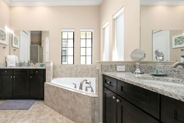 The en suite bathroom has a large soaking tub and granite counters