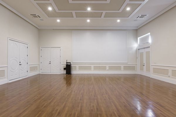 The area is complete with a projection screen and podium with microphone.