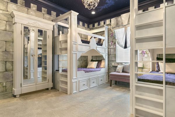 The princess castle themed kids bedroom has custom built twin over twin bunk beds