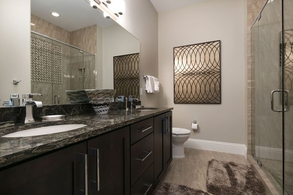 The en-suite bathroom with glass door walk-in shower and dual vanity