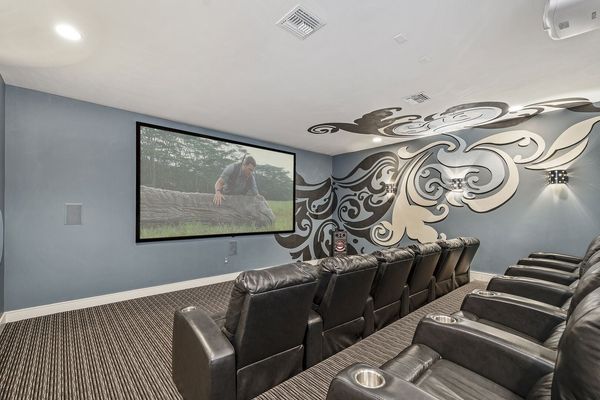 The theater room features a 150-inch projection screen, surround sound and a 4K Theatre Projector