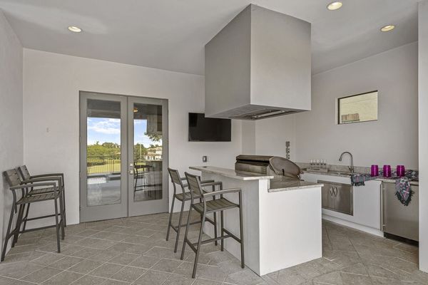 A summer kitchen is located underneath the covered lanai for delicious BBQ meals