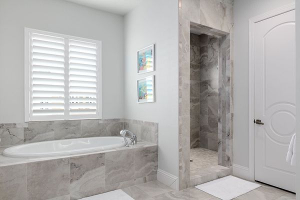 En-suite bathroom features a walk-in shower, dual vanity, and garden tub
