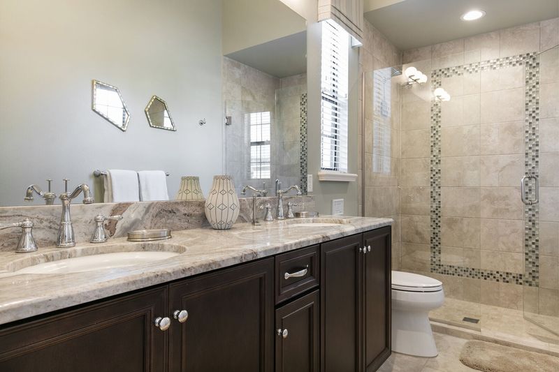En-suite bathroom with granite dual vanity and glass walk-in shower