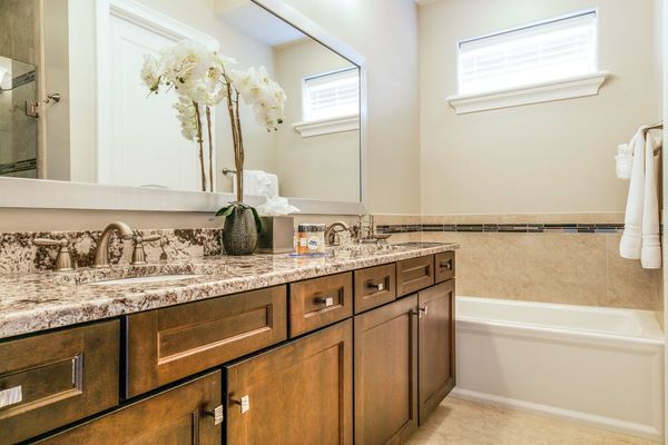 En-suite bathrrom with dual vanity, walk-in shower, and tub