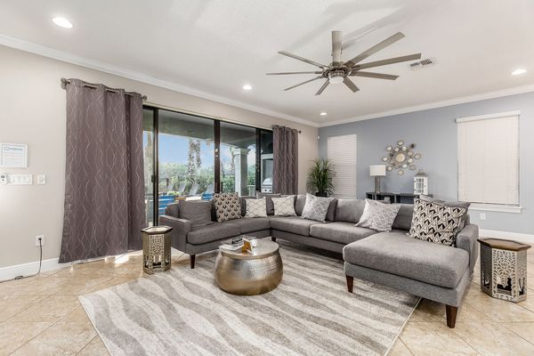 The living area has a comfortable seating for all with a beautiful pool view