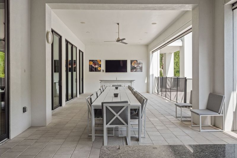 Dine al fresco under the covered lanai. The pool safety fence provides an added layer of protection